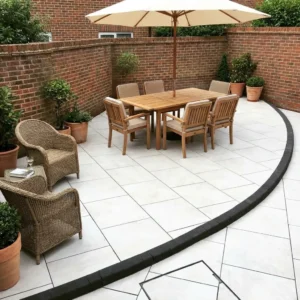 A patio paved with Aosta White Outdoor Porcelain Paving Tiles (600x900x20mm) features a wooden dining table, six matching chairs, an umbrella, two wicker chairs, potted plants, and is surrounded by brick walls.