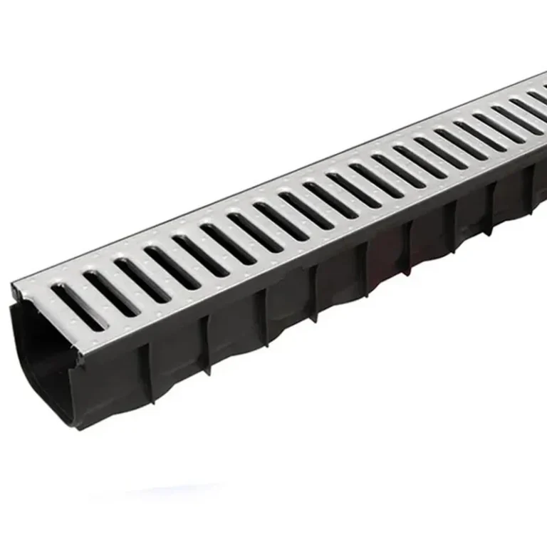 A black plastic Aco Drain with a silver metal grate cover, featuring rectangular slots for water drainage, shown against a white background.