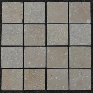 A grid of sixteen Yellow Limestone Sawn Edge Setts 100x100x40mm, each square tile featuring subtle color and texture variations, arranged in four rows and four columns against a dark background.