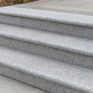 Close-up of four Silver Grey Granite Bullnose Steps (900x350x35mm), showcasing smooth, light gray granite leading to a landing with matching paving. The steps are clean, well-aligned, and visually appealing.