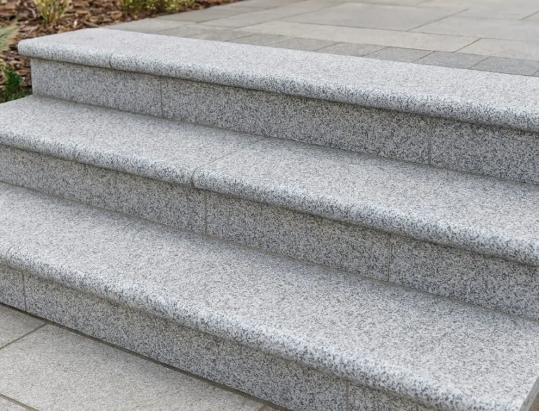 Close-up of four Silver Grey Granite Bullnose Steps (900x350x35mm), showcasing smooth, light gray granite leading to a landing with matching paving. The steps are clean, well-aligned, and visually appealing.