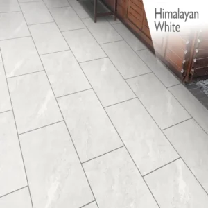A patio featuring large, rectangular tiles in a soft gray, nearly white hue offers a sleek and contemporary appearance with a subtle texture. In the background, you can see a wooden fence. The words "Himalayan White Outdoor Porcelain Paving Tiles - 600mm x 900mm x 20mm" are displayed in the top right corner.
